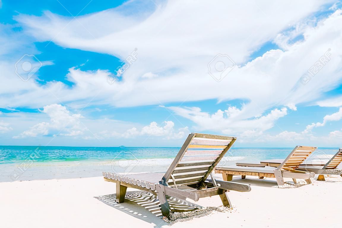 하얀 모래 해변의 비치 의자 맑은 하늘은 일광욕을 즐기기에 완벽합니다. 또는 여름 주말에 휴식을 취하십시오.