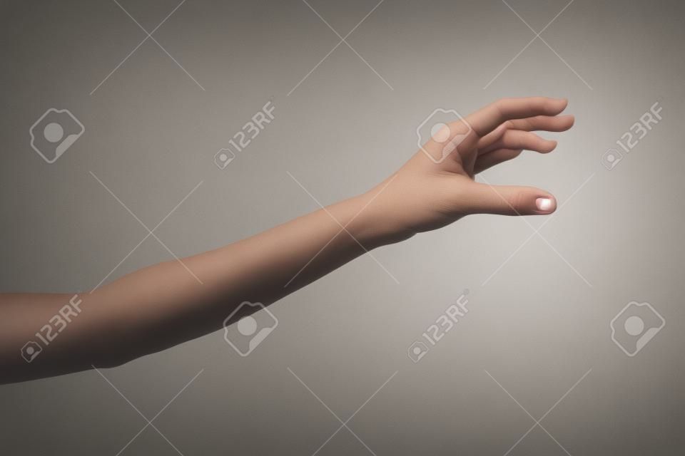 mão da mulher é alcançar pegar algo isolado no fundo branco