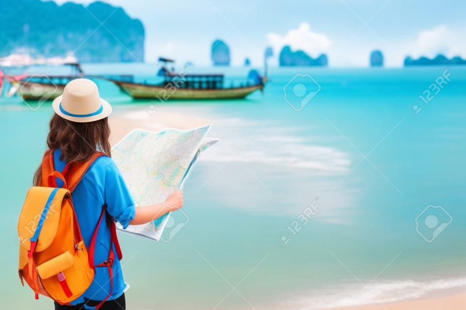 젊은 여자 여행자 하늘 파란색 배낭과 모자 긴 보트 태국 바다에서지도 찾고 Ao Nang 해변 크 라비에서 배경입니다. 크라비 태국, 여행자 여름 개념 여행