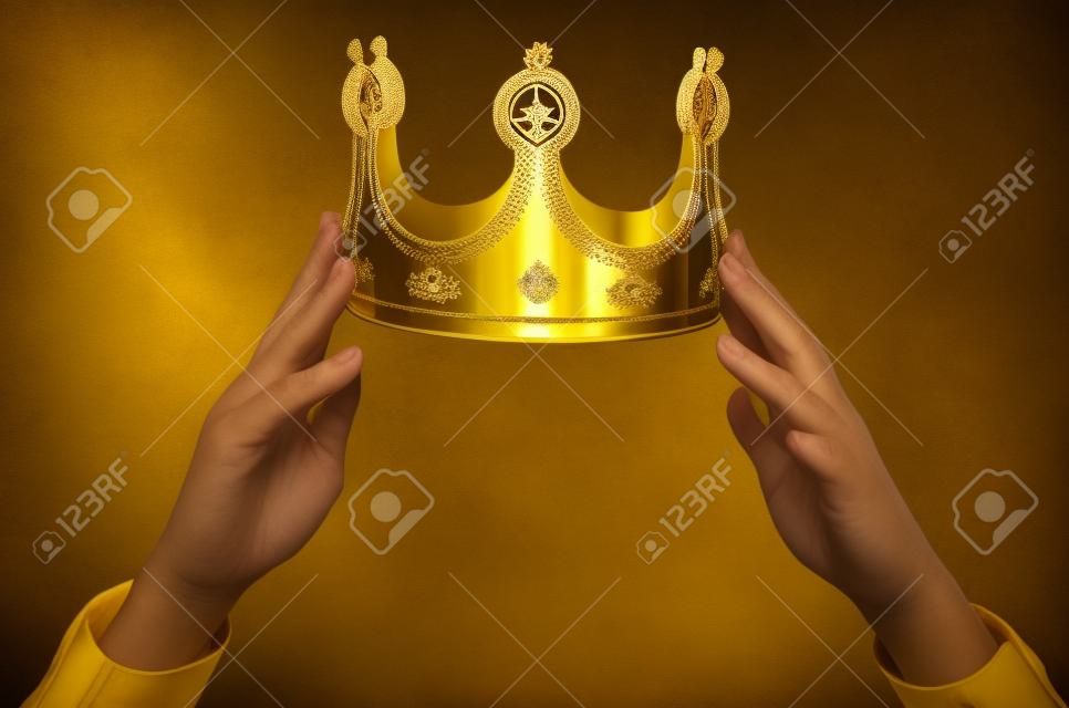 머리 위에 황금 왕관을 들고 손. 수상자 시상식. 자기 선언 개념.