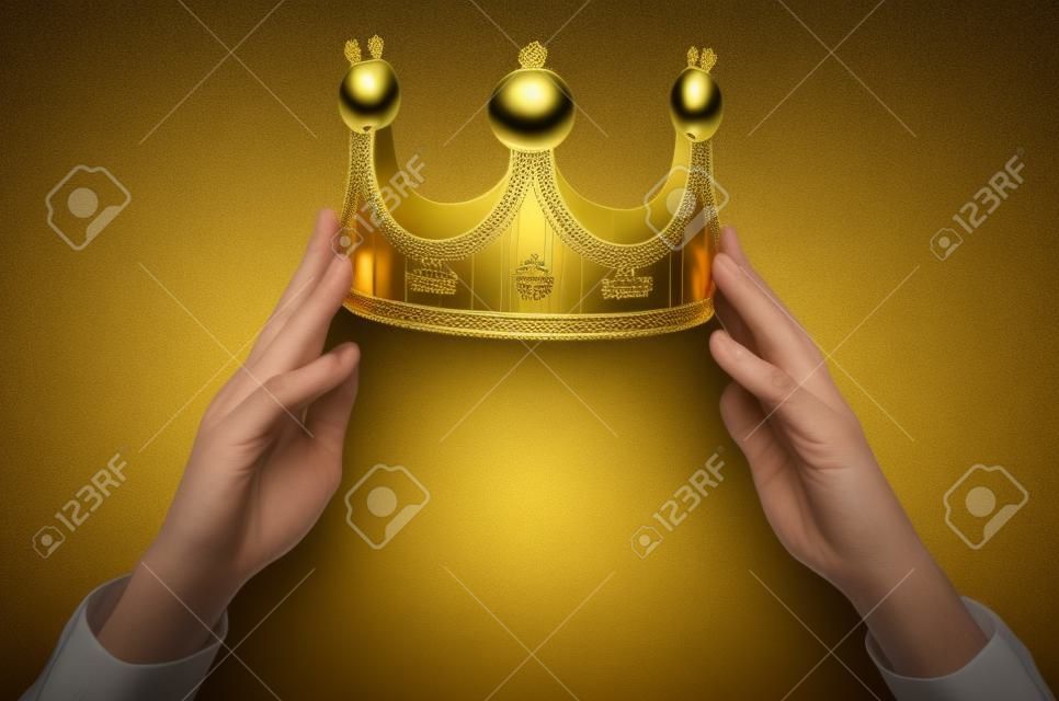머리 위에 황금 왕관을 들고 손. 수상자 시상식. 자기 선언 개념.
