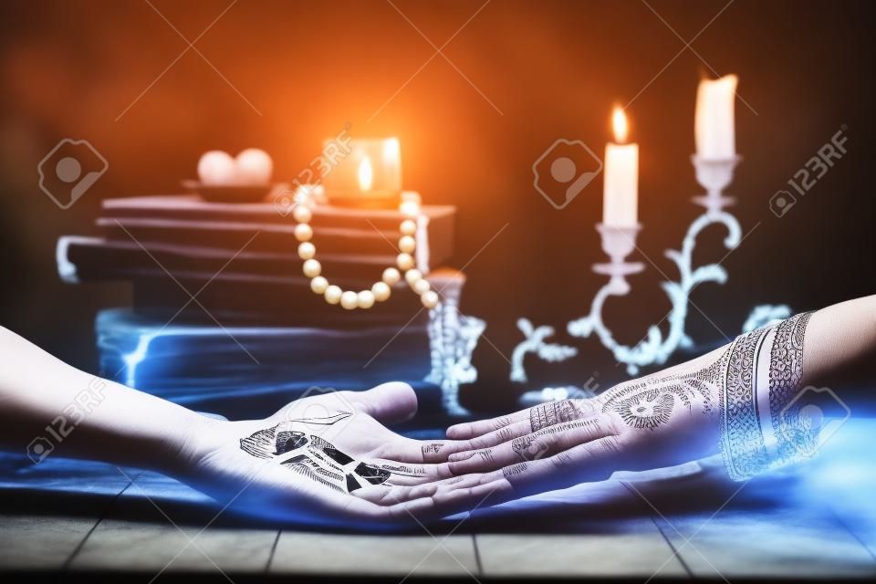 Palmistry concept. Fortune teller reading future on the hand on a magic table background. Future reading concept.