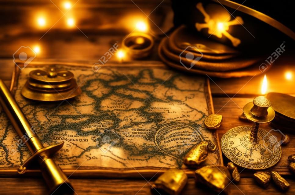 Pirate treasure map, gold nuggets, dagger and pirate hat on aged wooden table background. Sea travel.