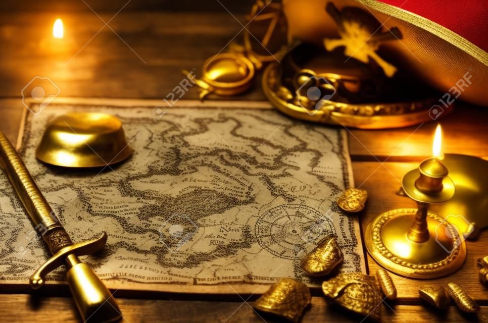 Pirate treasure map, gold nuggets, dagger and pirate hat on aged wooden table background. Sea travel.