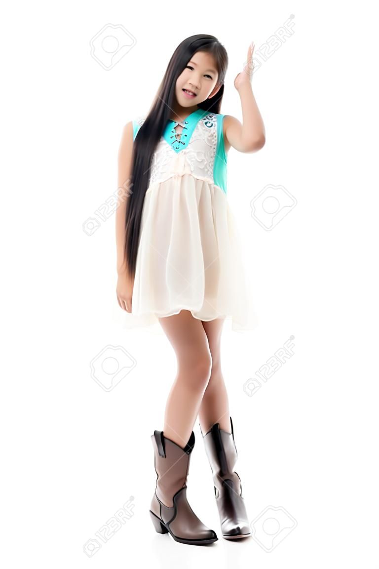 Cute Asian teenager wearing dress and boots on white.