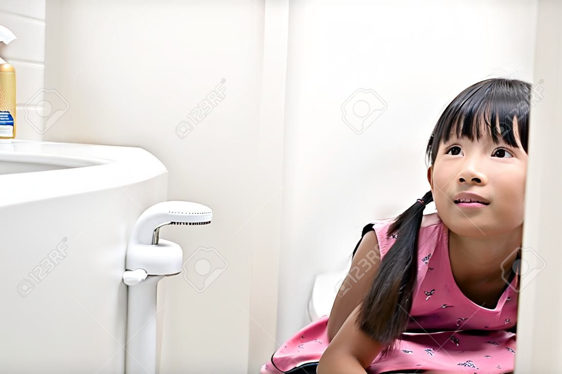 トイレに座っているアジアの女の子