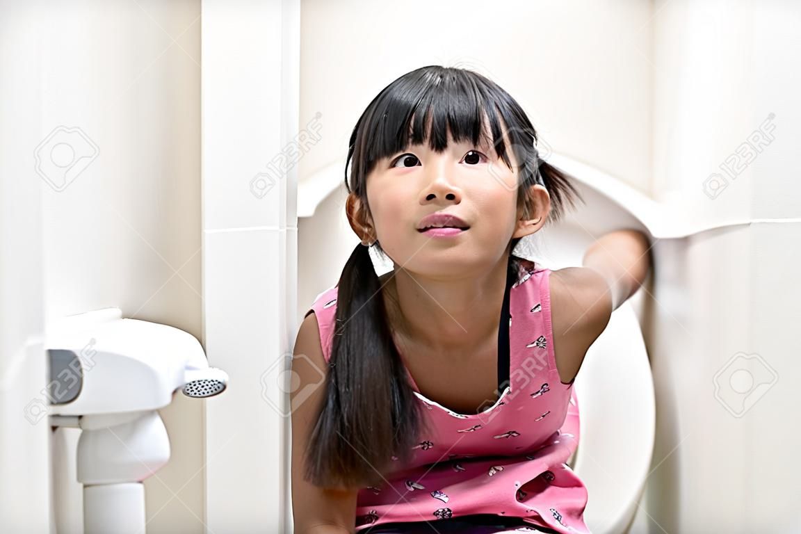 トイレに座っているアジアの女の子