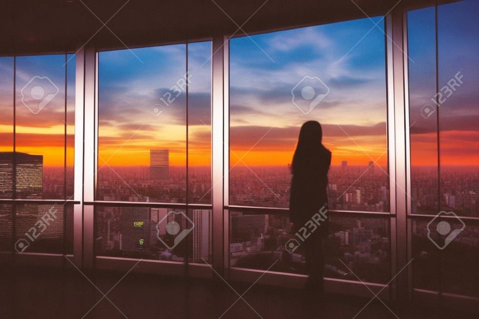 Vue arrière de la femme voyageur regardant Tokyo Skyline et vue sur les gratte-ciel sur le pont d'observation au coucher du soleil au Japon. Ton vintage