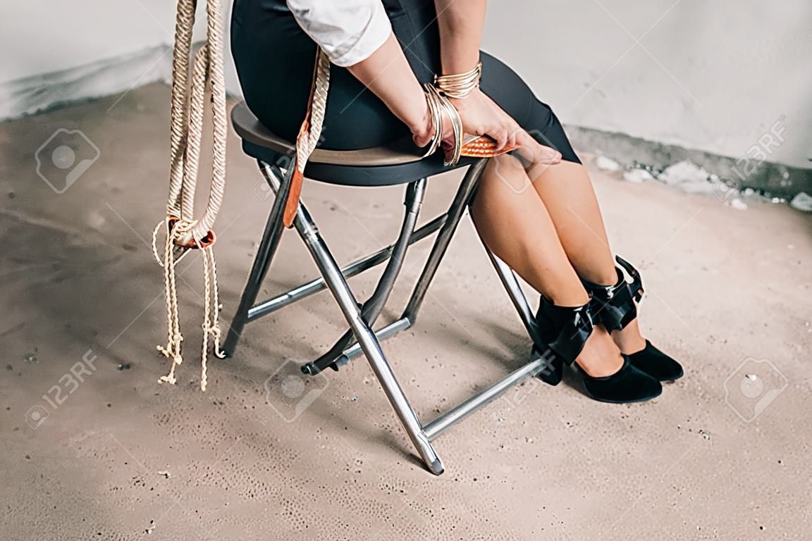 woman hands bound. Women were handcuffed and Sitting on a chair.woman tied hand to a chair.Crime Concept.Criminality Concept. Bonded business.