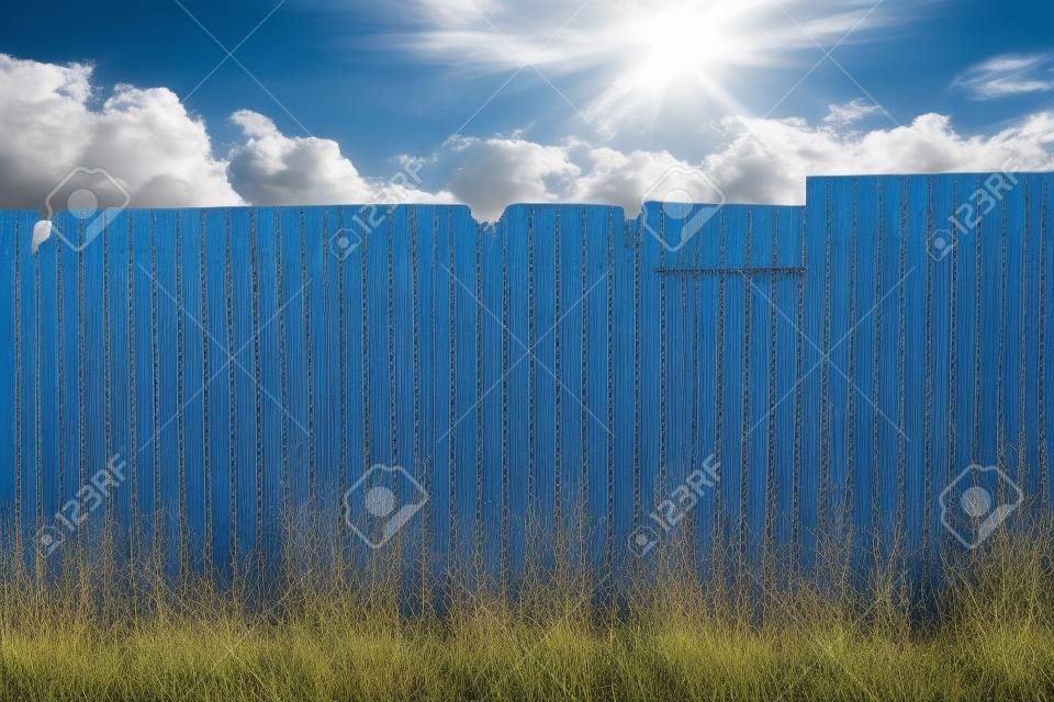 Rusty galvanized corrugated fence with the blue sky and cloudy