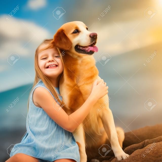 Un enfant avec un chien dans la nature au bord de la mer s'amuse. photo de haute qualité.