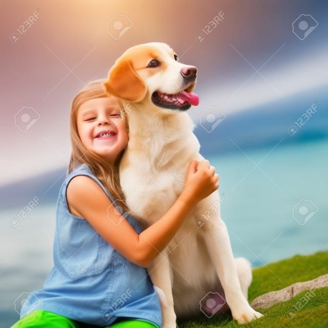 Un enfant avec un chien dans la nature au bord de la mer s'amuse. photo de haute qualité.