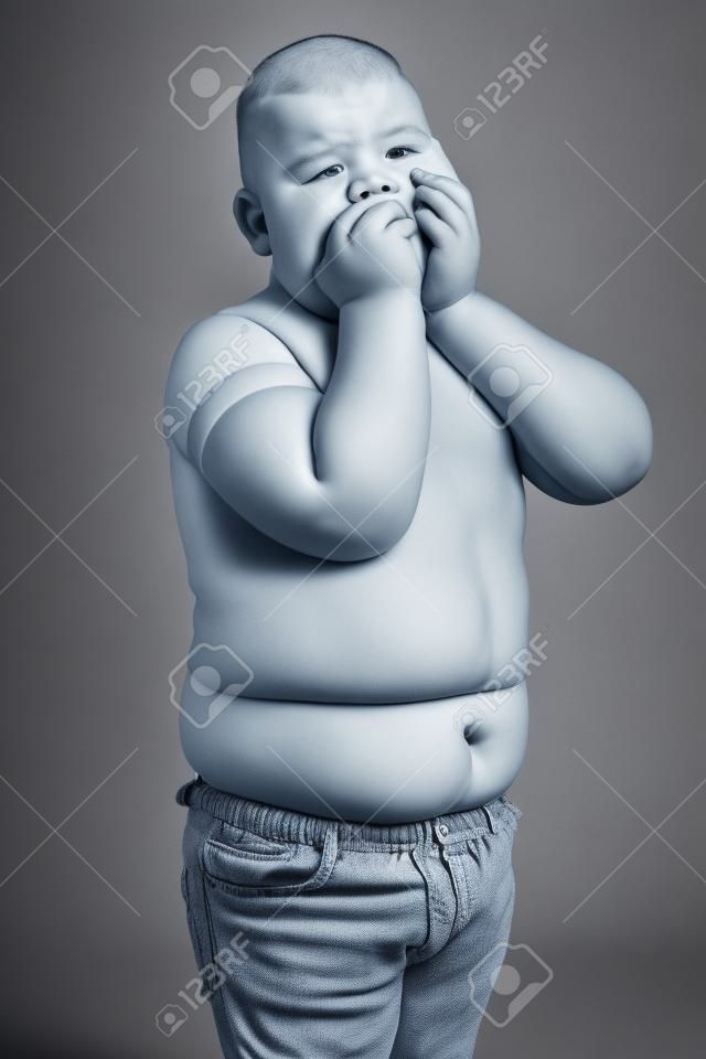 Ein Junge mit Stoffwechselstörungen. Kind mit dem Problem der Fettleibigkeit bei Kindern. Übergewichtiger fettleibiger fetter Junge. Foto in hoher Qualität.