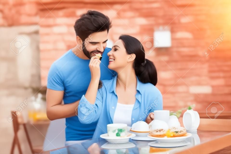 Heureux couple romantique ayant le petit déjeuner ensemble, se nourrissant les uns des autres.