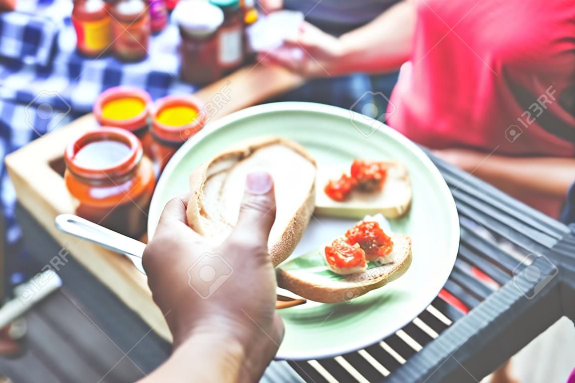 Nahaufnahme einer Handhalteplatte mit Brotscheiben und Ajvar-Proben beim Street Market Food Festival.