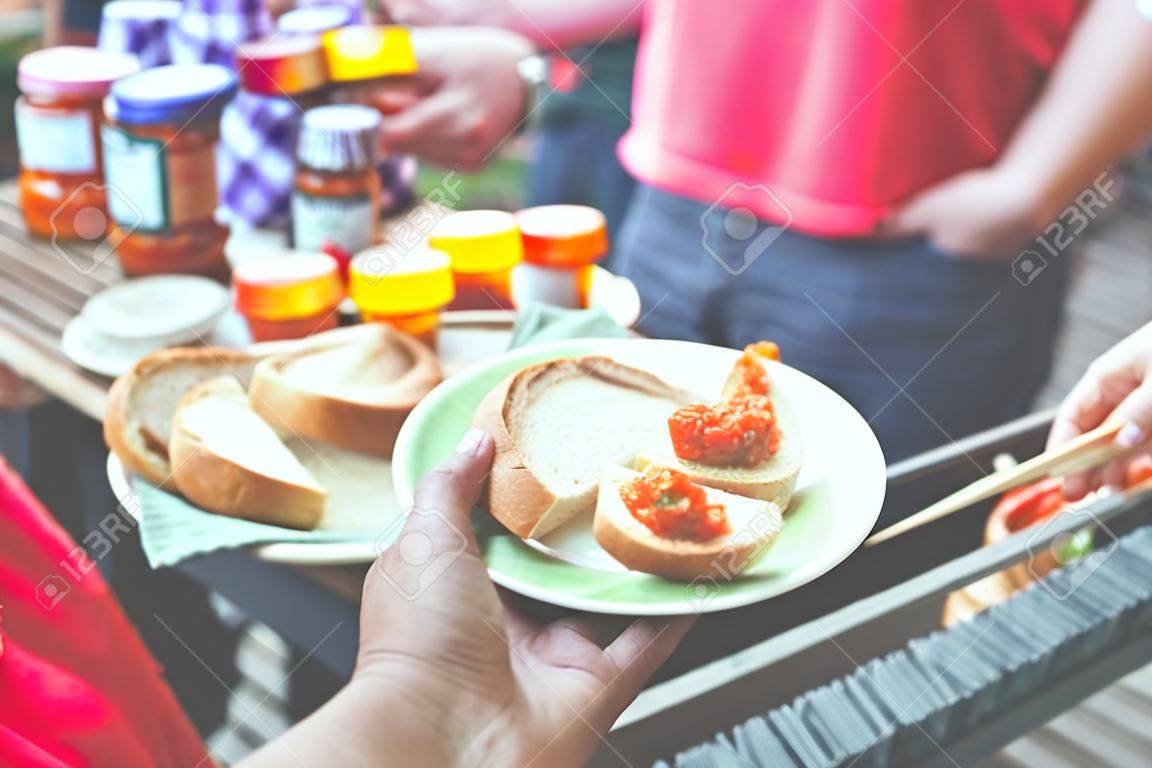 Nahaufnahme einer Handhalteplatte mit Brotscheiben und Ajvar-Proben beim Street Market Food Festival.