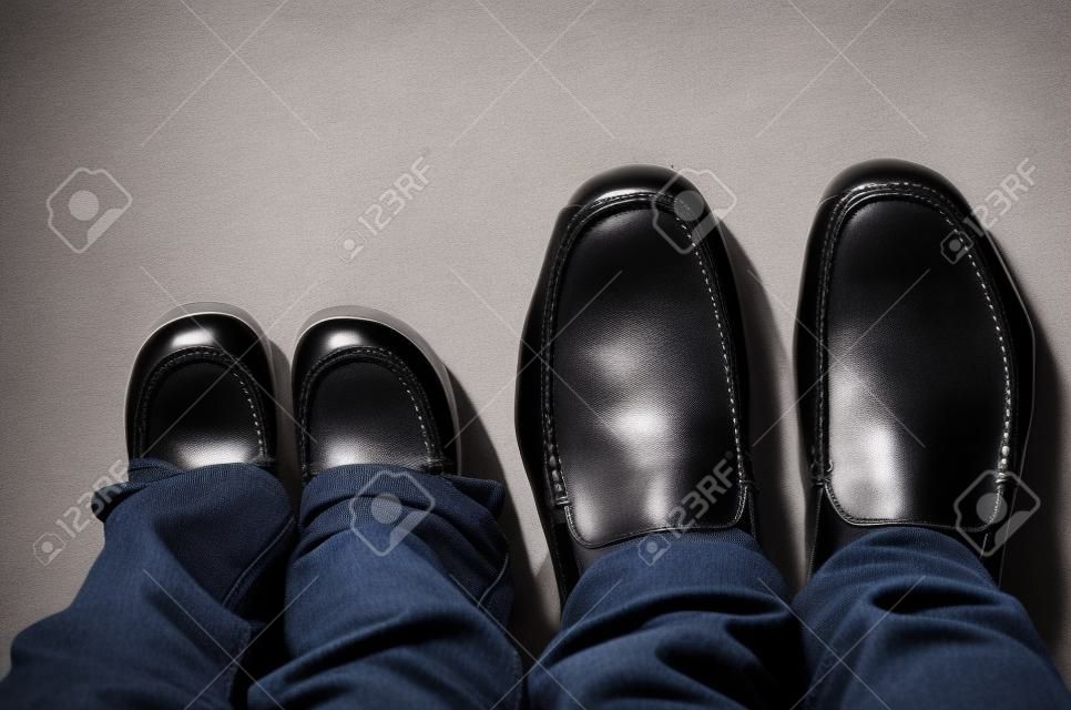 Zapatos en las piernas de un padre y su hijo