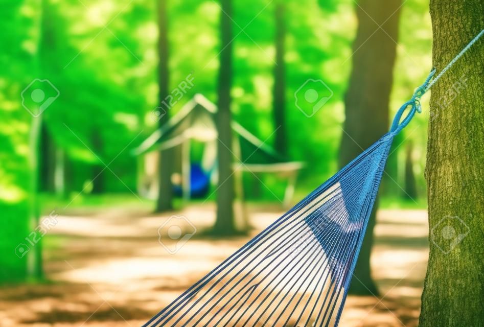 Hangmat voor camping close-up van de achtergrond van gebouwen en bossen op een zonnige dag.