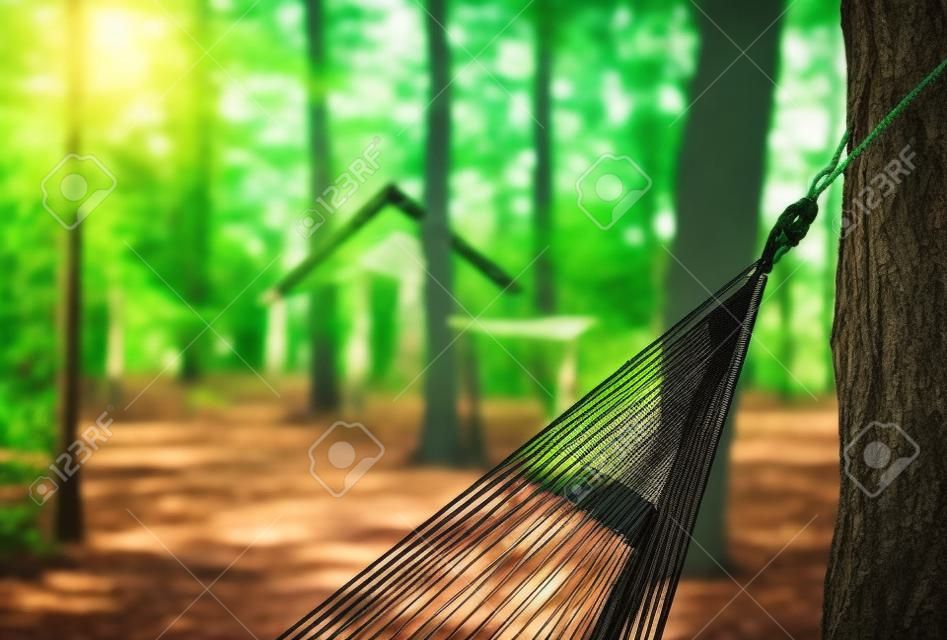 Hammock for camping close-up to the background of buildings and forests on a Sunny day.