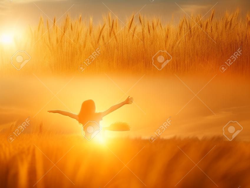 Девушка насладиться с солнцем в поле пшеницы