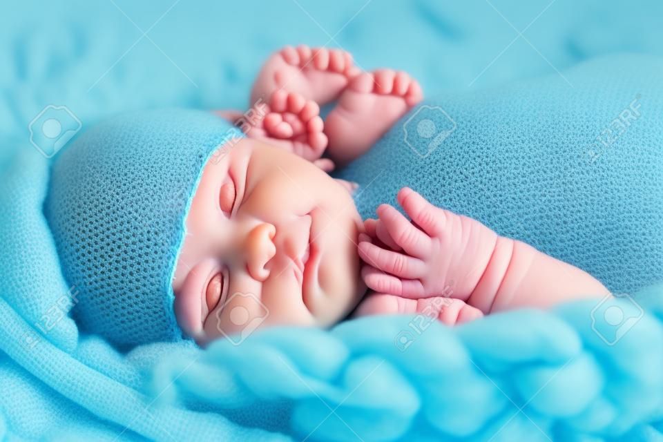Il neonato sulla coperta di crochet giganti blu cerca