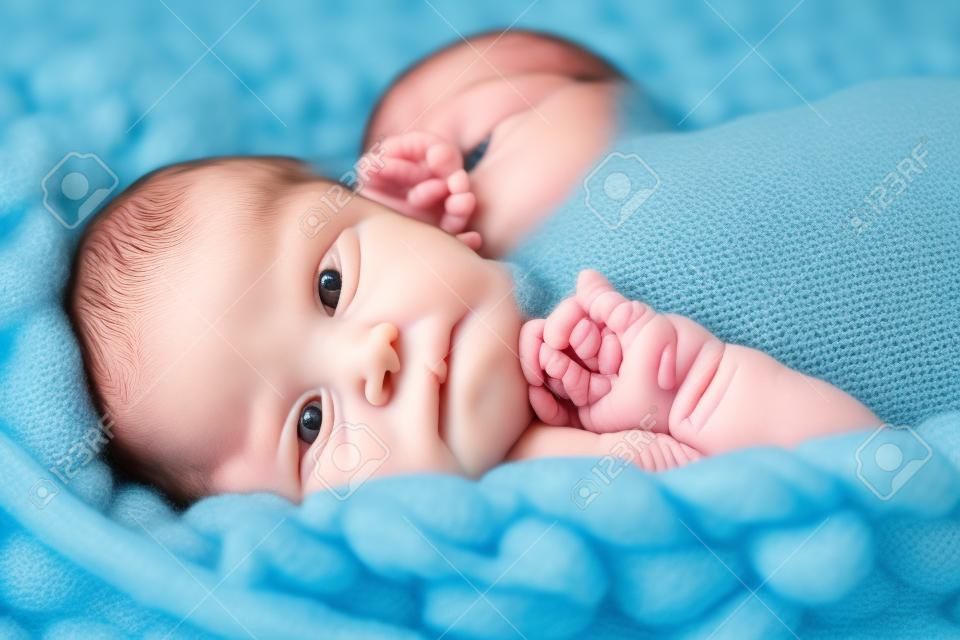 Newborn baby on blue giant crochet blanket look up