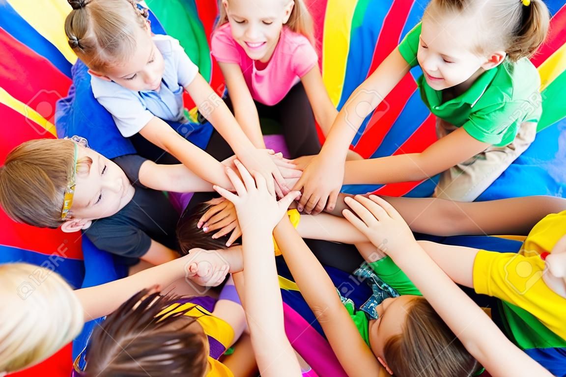 Close view of group of kids with their hands one on another