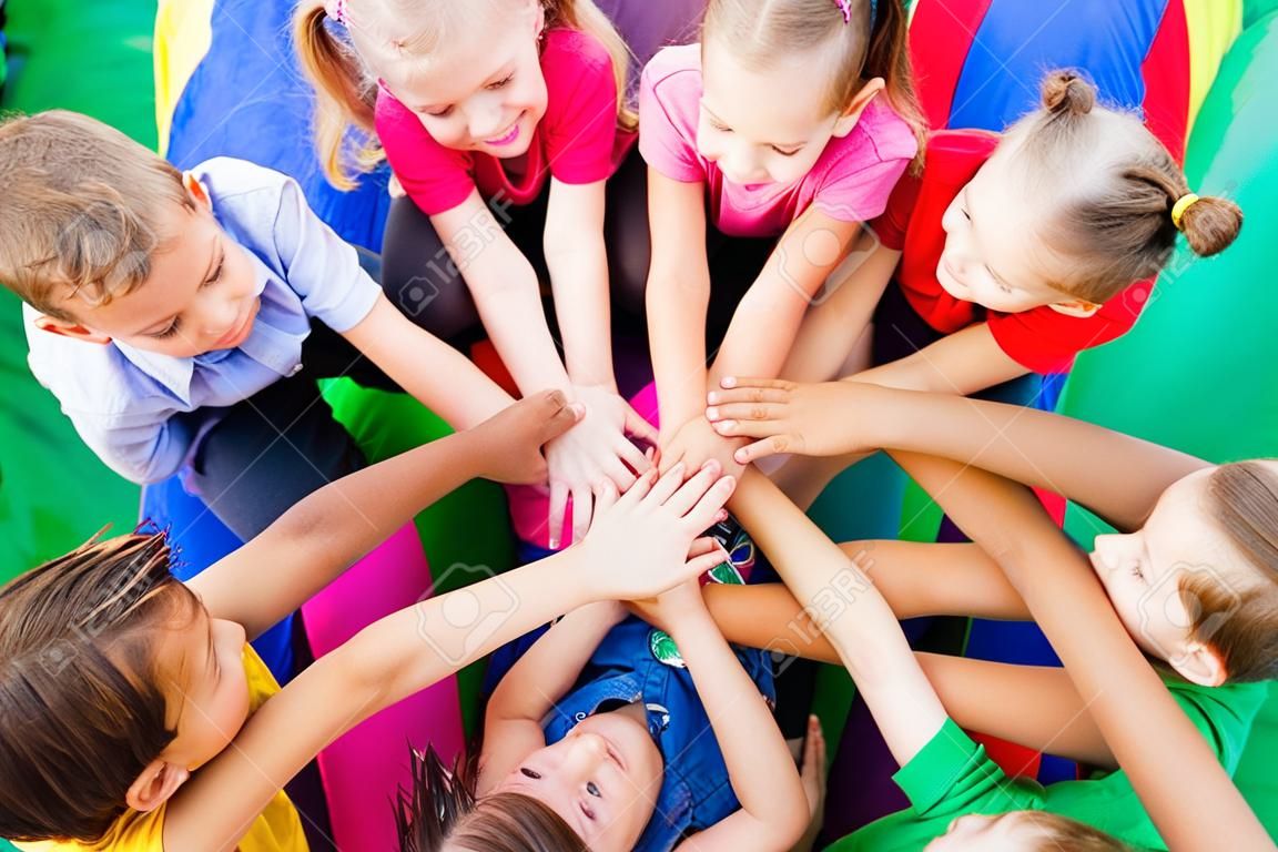 Close view of group of kids with their hands one on another