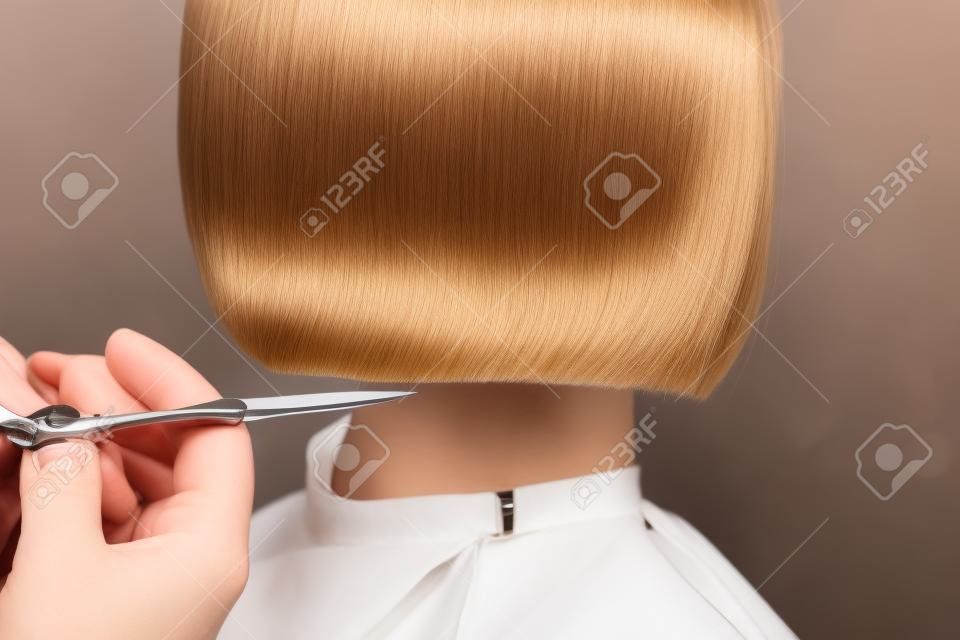 Zbliżenie rąk profesjonalnej stylistki fryzur robi krótkie włosy nożyczkami, koncepcyjny salon kosmetyczny, fryzjerka