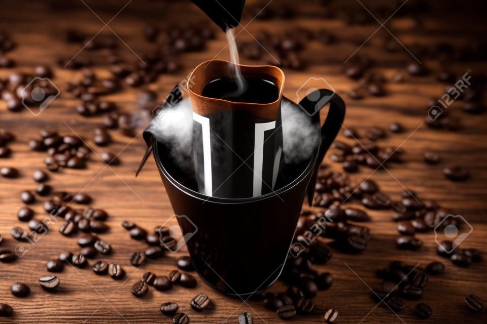 Brewing coffee in a Cup through a filter, on a dark wooden background