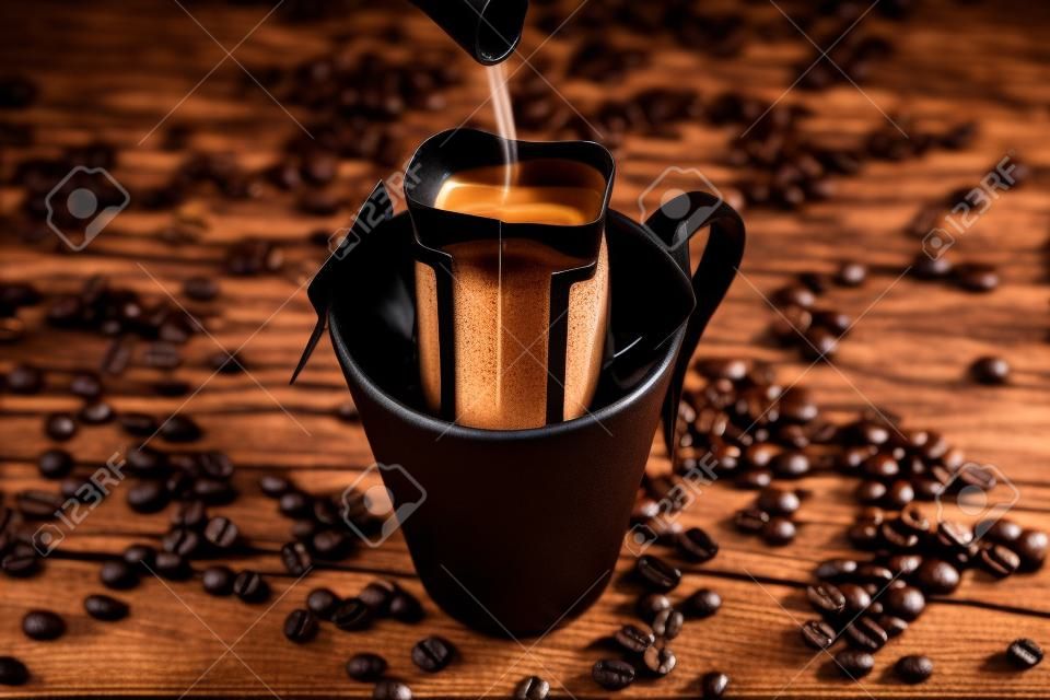 Brewing coffee in a Cup through a filter, on a dark wooden background