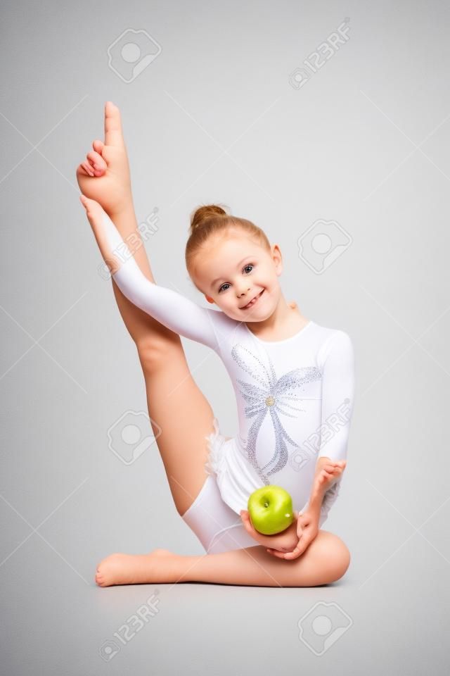 junge Mädchen Turnerin mit gesunden Lebensmitteln Apfel auf weißem Hintergrund