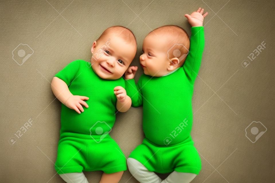 funny twins Brüder Babys liegen auf grünen