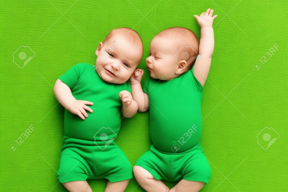 śmieszne dzieci bliźnięta bracia leżącego na zielony