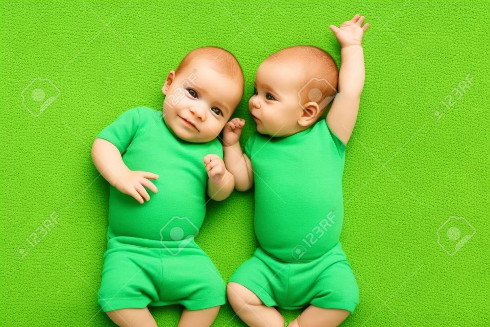 смешные близнецы братья детей лежала на зеленом
