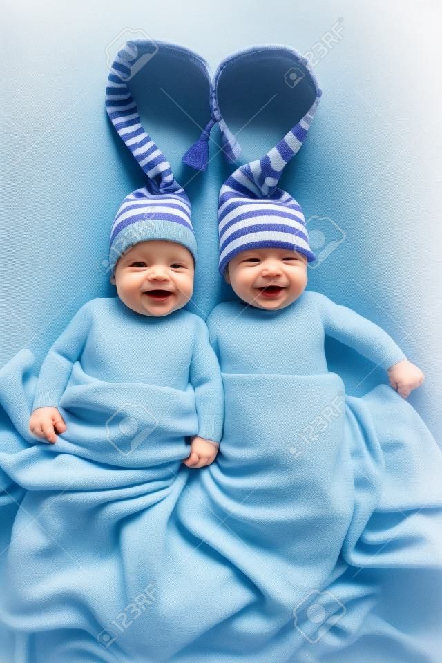 dos hermanos gemelos bebés weared en sombreros atados por la forma del corazón