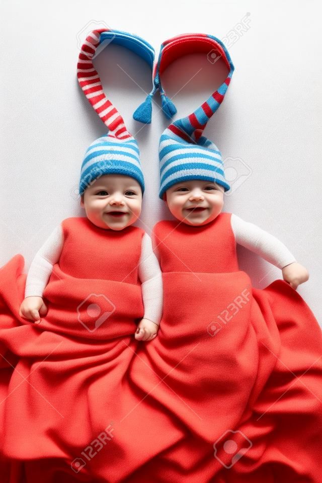 dos hermanos gemelos bebés weared en sombreros atados por la forma del corazón
