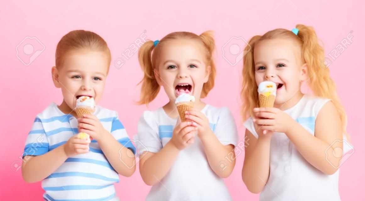muchacho felices a los niños y niñas de comer helado en estudio aislado