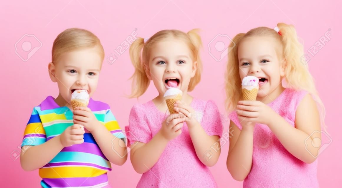 muchacho felices a los niños y niñas de comer helado en estudio aislado