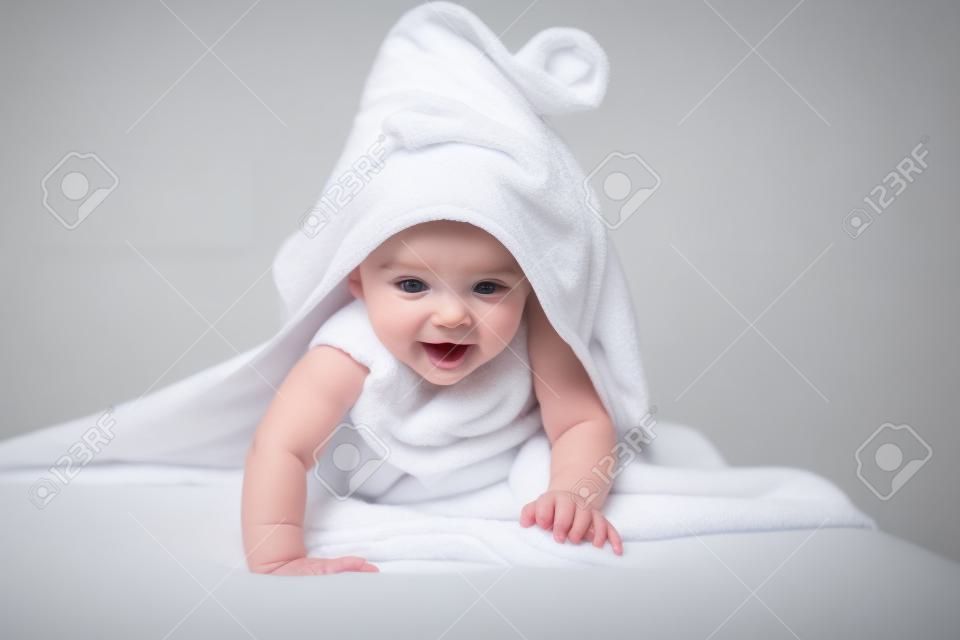 bebé bajo la toalla después de bañarse en el hogar