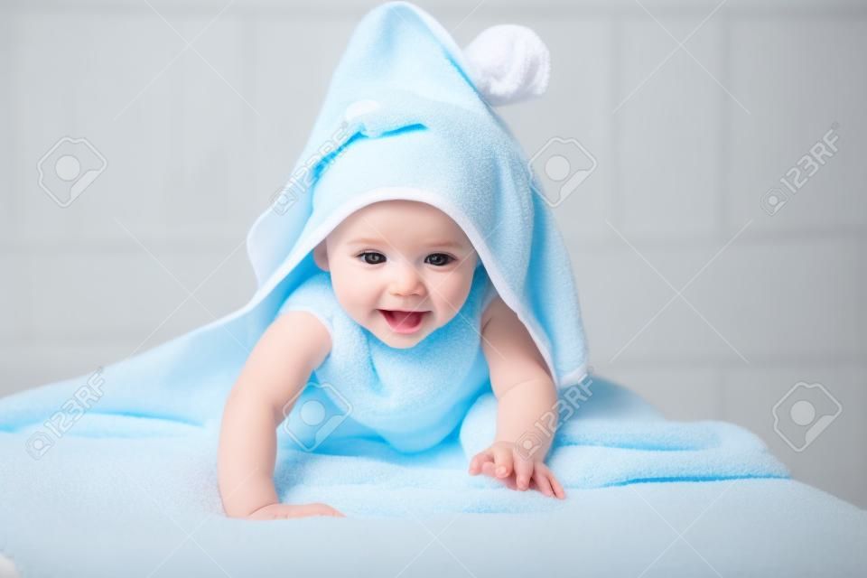 bebé bajo la toalla después de bañarse en el hogar