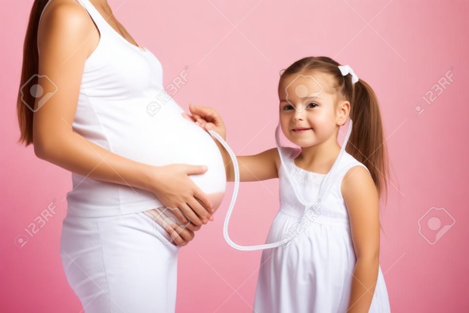 kid girl listening to pregnant mom tummy isolated