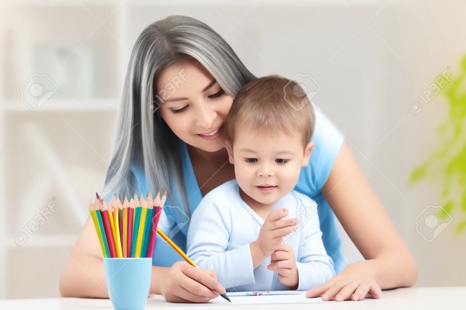 happy family concept - mother and child boy drawing pencils