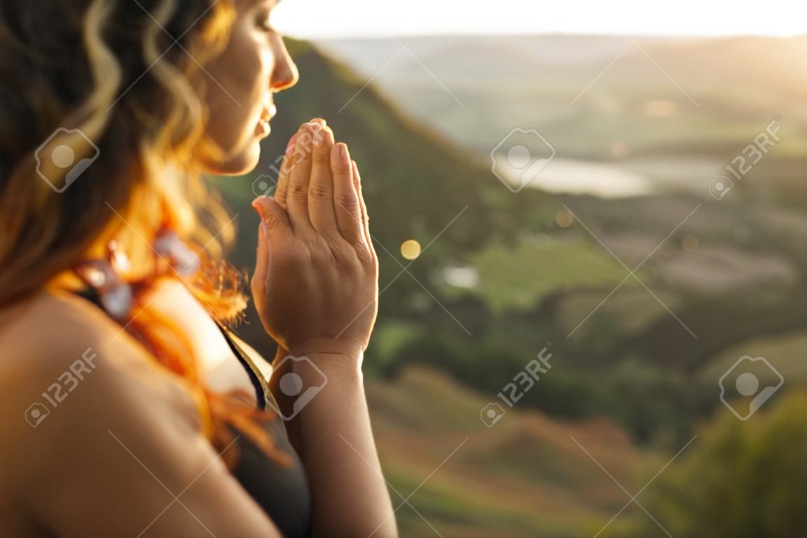 Mujer rezando sola al amanecer. Fondo de la naturaleza. Concepto espiritual y emocional. Sensibilidad a la naturaleza