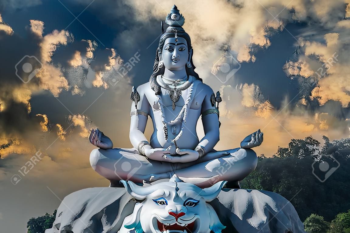 Posąg medytującego hinduskiego boga śiwy na tle nieba i chmur na rzece ganges w wiosce rishikesh w indiach, z bliska