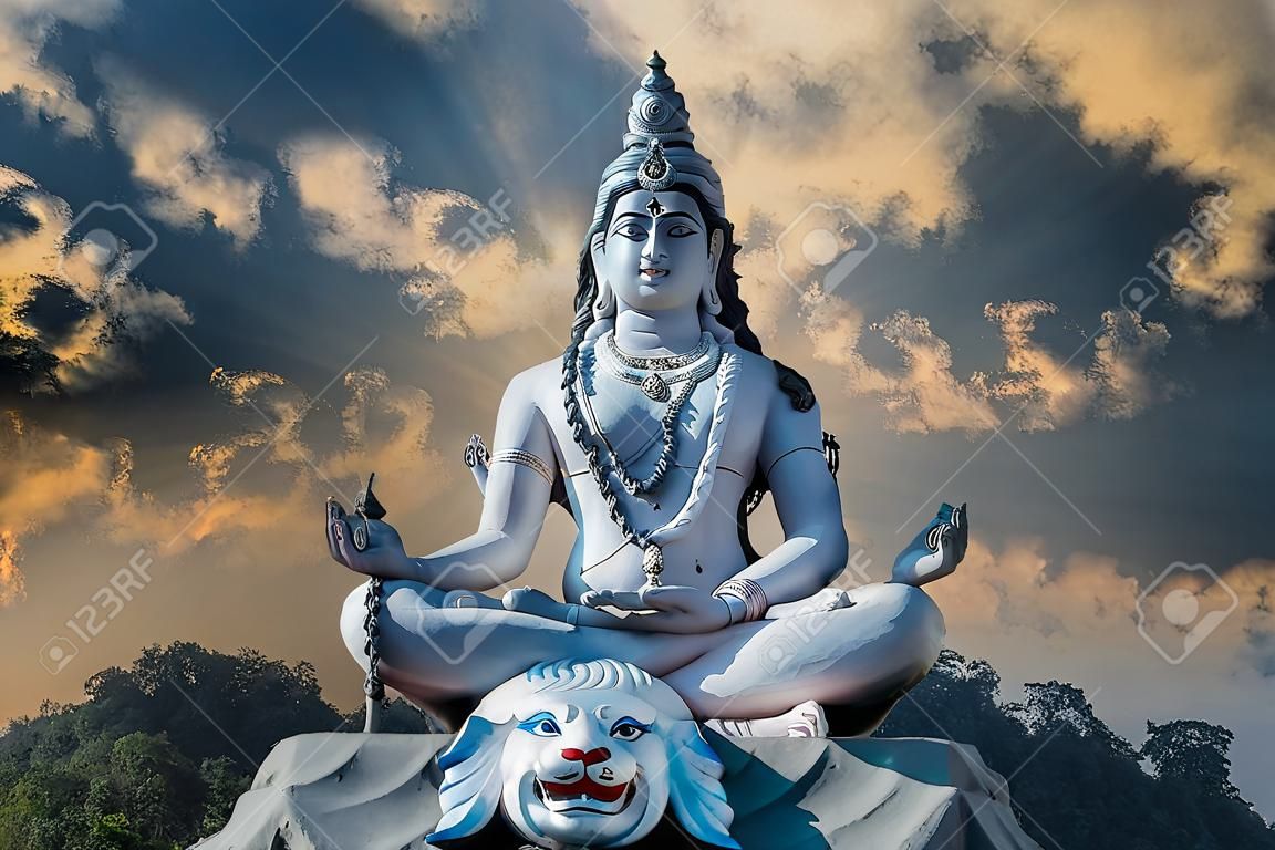 Posąg medytującego hinduskiego boga śiwy na tle nieba i chmur na rzece ganges w wiosce rishikesh w indiach, z bliska