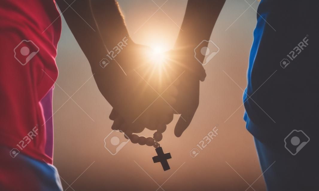Paar zusammen beten. Rosenkranz in der Hand halten.