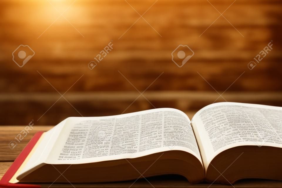 Santa Biblia con cuaderno y lápiz sobre la mesa de madera contra la luz del sol de la mañana para la devoción cristiana, espacio de copia