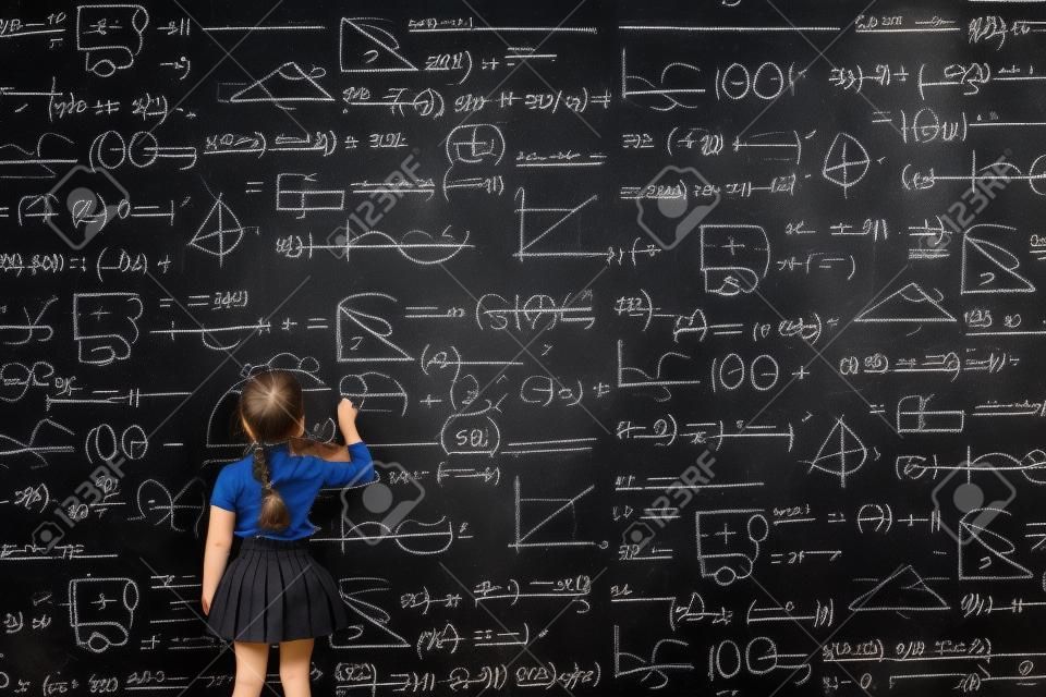 Schoolgirl writes on the blackboard formulas and mathematical equations