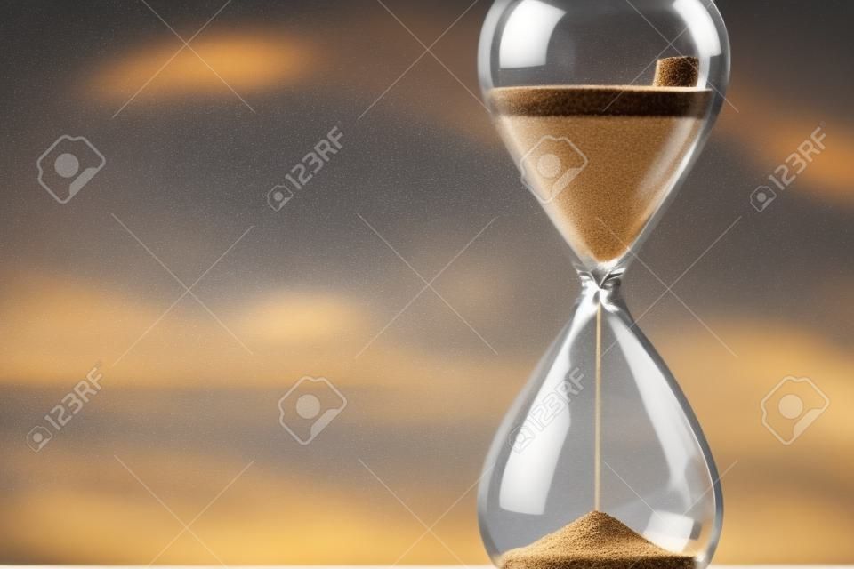 Reloj de arena moderno con fondo de ventana borroso: arena que se filtra a través de los bulbos de un cristal de arena. cada segundo cuenta. símbolo del tiempo. cuenta regresiva.